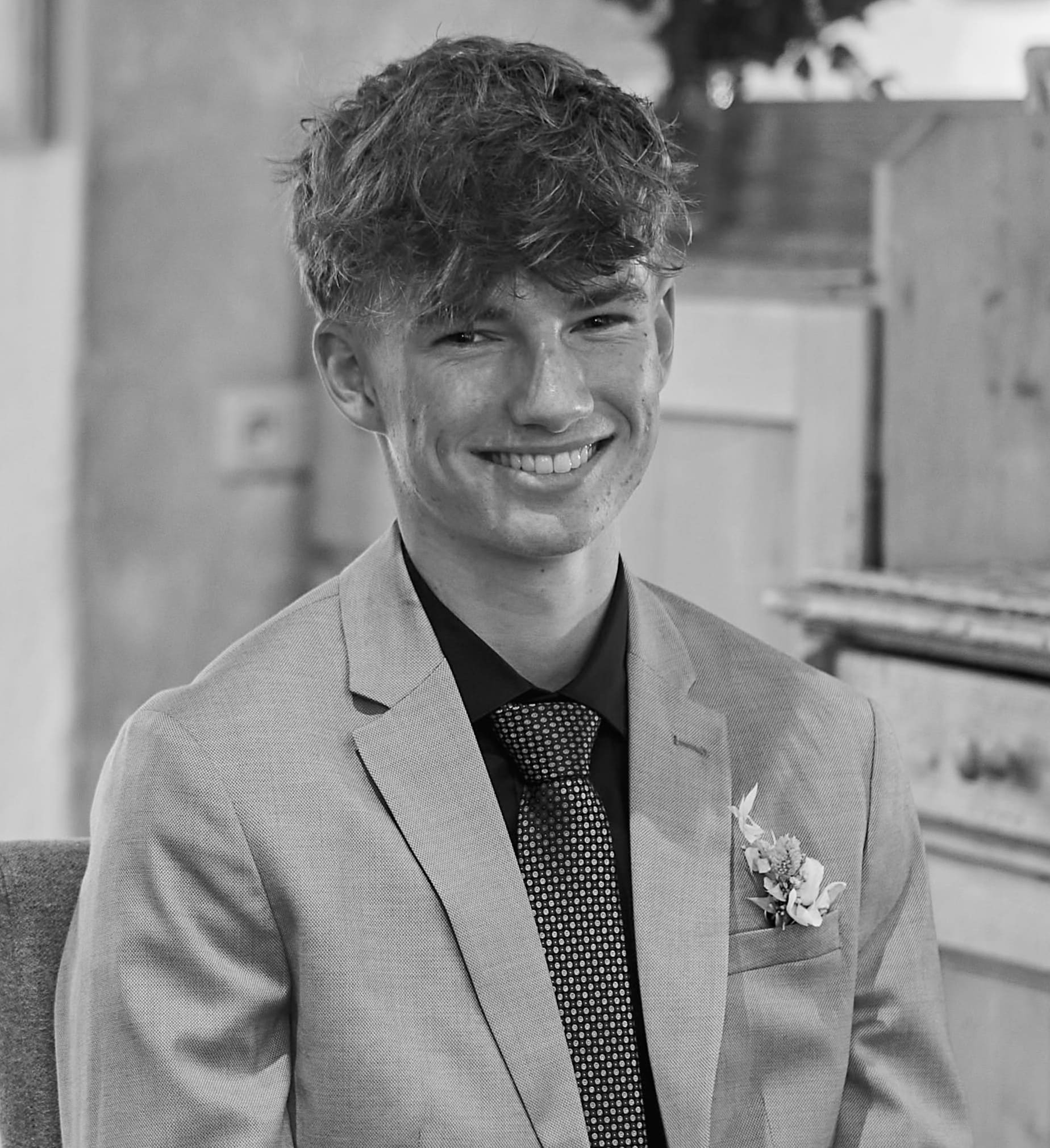 Jannis Danner - Gründer von XENTA FILMS mit einem Anzug und einem Lachen im Gesicht