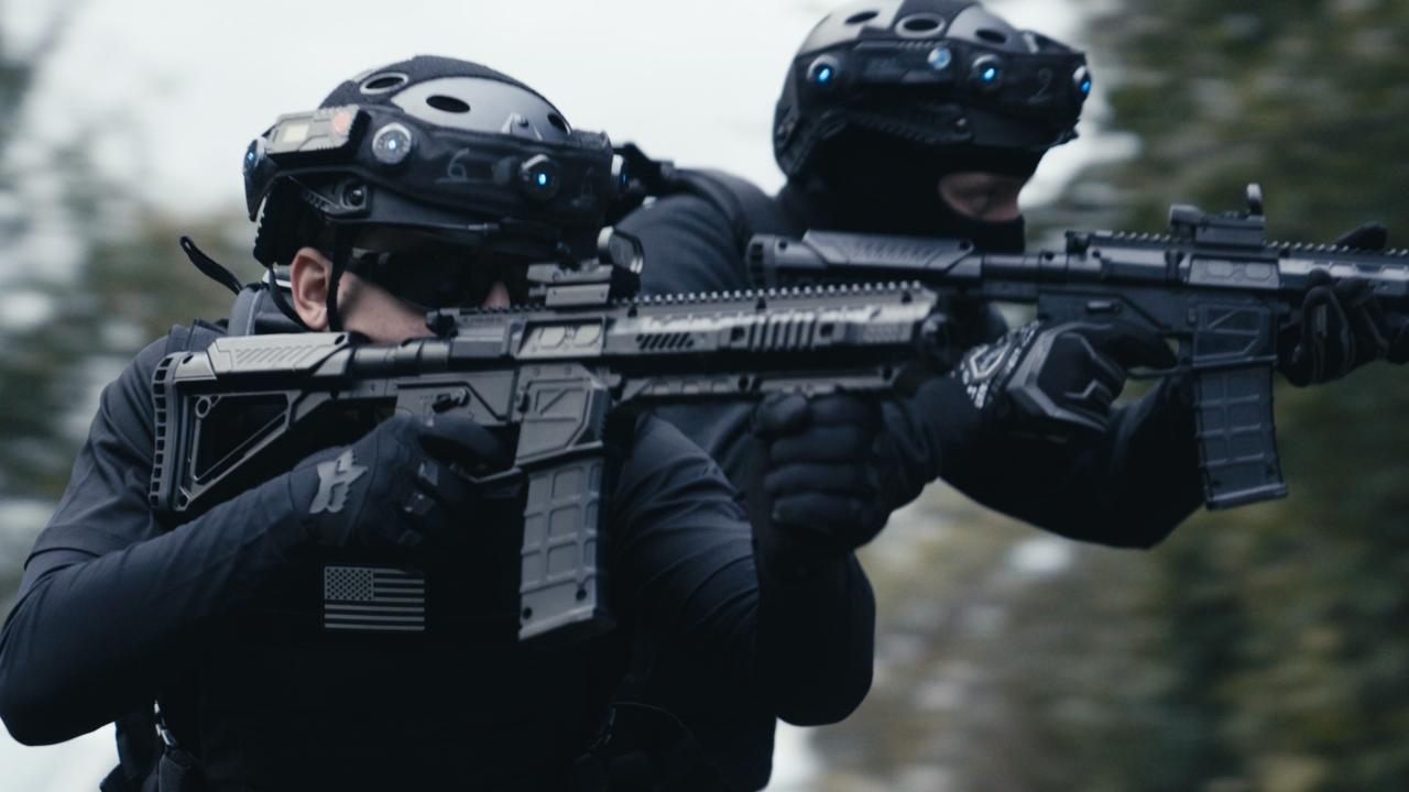 Zwei Männer in SWAT-Uniform mit Helm, Sturmhaube und Sonnenbrille halten jeweils eine Waffe, sie stehen im Wald bei der Outdoor-Lasertag-Arena von Lasertag Pro in Wels. Szene aus dem Projekt "The Extraction".