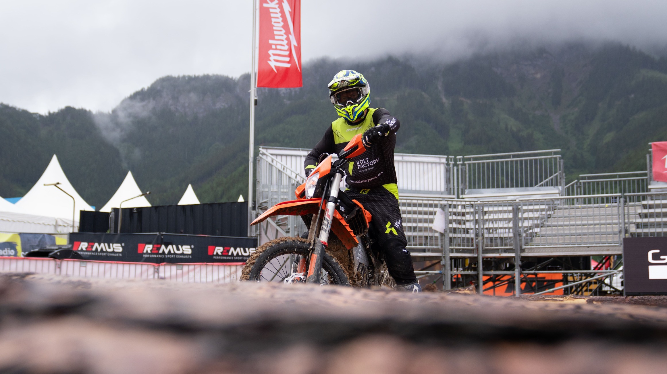 Jakub Zręda auf der KTM FREERIDE E vor den Tribünen am Erzberg, die Berge in Wolken