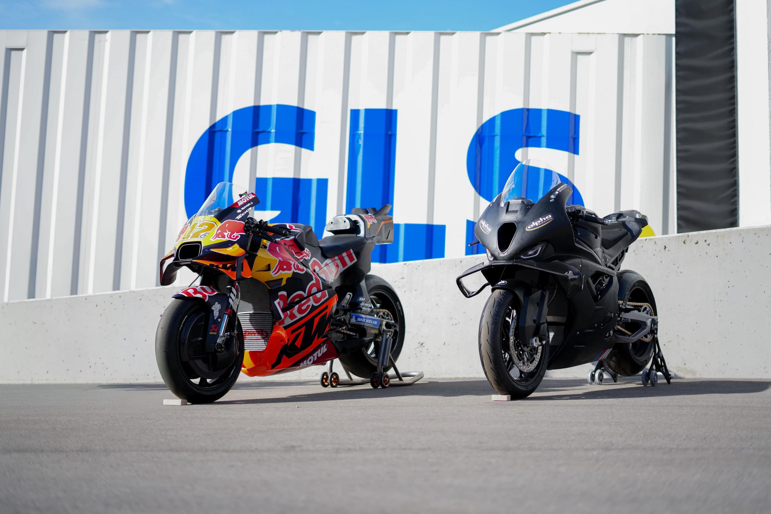 KTM MotoGP RC16 und BMW M1000RR von AlphaRacing vor der Firmenwand beim AB Moto Sommerfest 2026