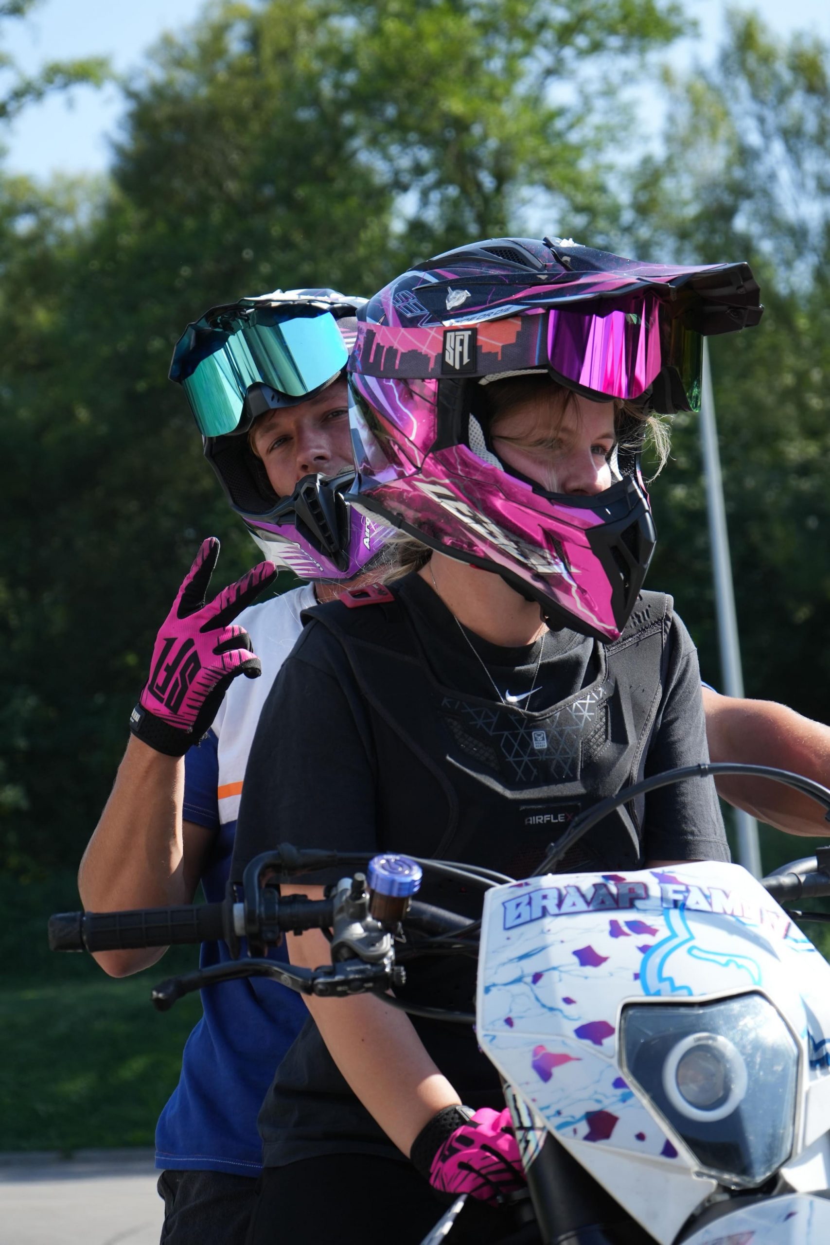 Stuntfahrerin lessi.bklf mit pinkem Helm zu zweit auf dem Motorrad beim Sommerfest von AB-Moto