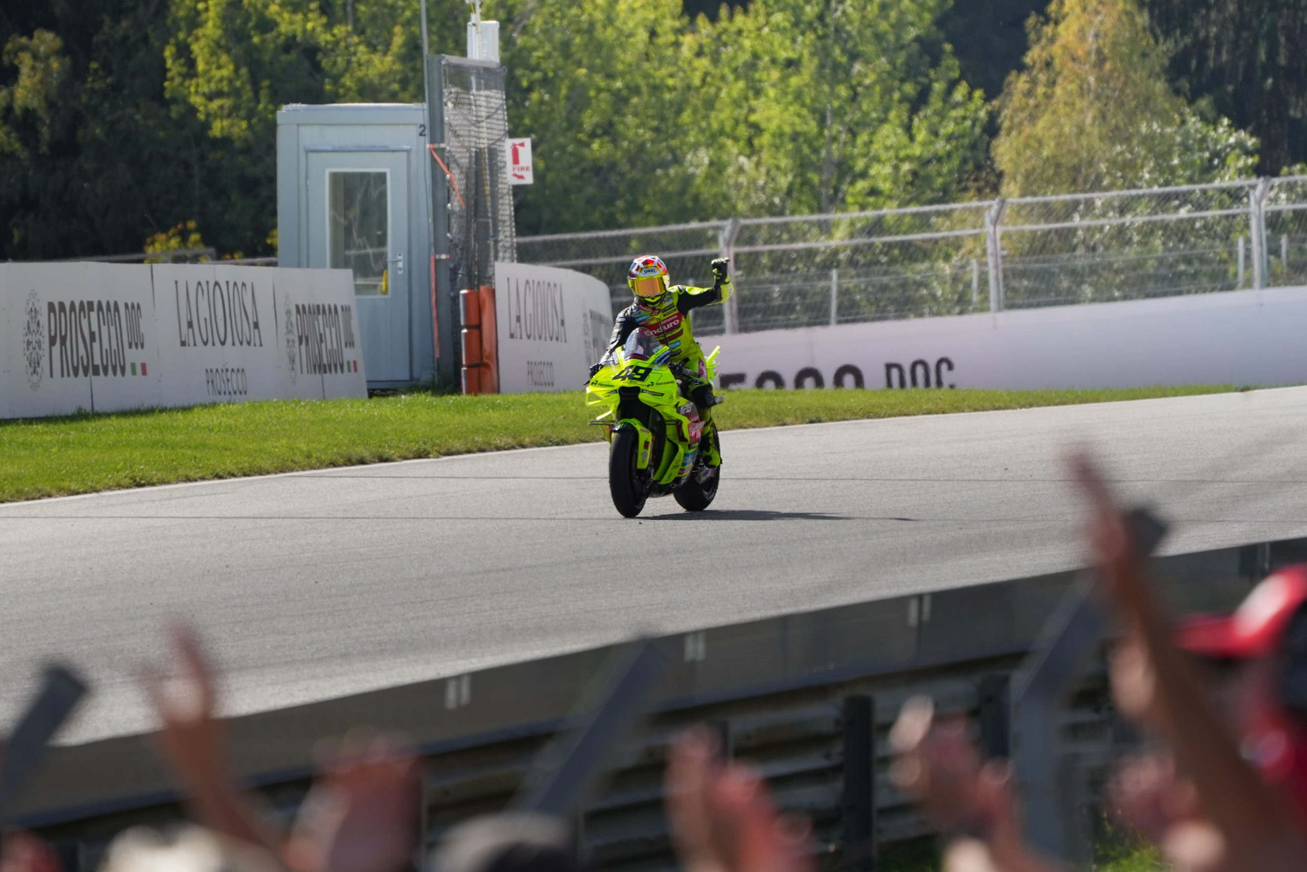 Fabio Di Giannantonio auf der neongelben Ducati fährt an jubelnden Zuschauern in Spielberg vorbei