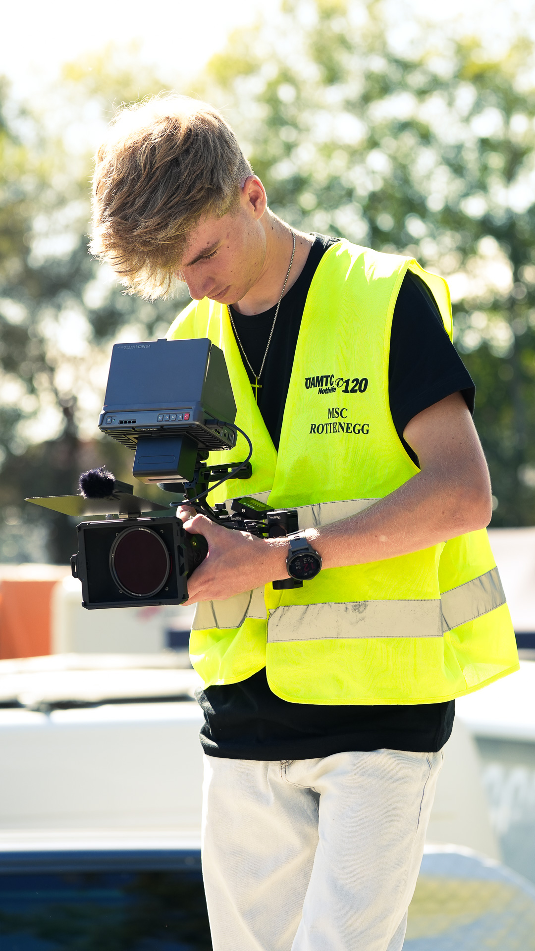 Jannis Danner filmt mit Kamera und Monitor in der Presseweste des MSC Rottenegg