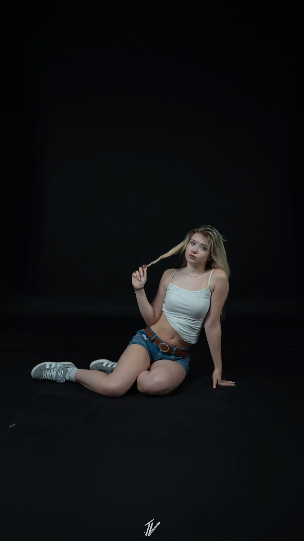 Model Naemi Krösche in einer lockeren Sitzpose im Studio.