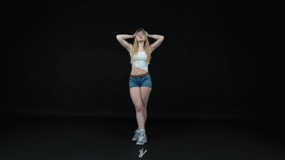 Naemi Krösche steht im weißen Top vor dunklem Hintergrund.