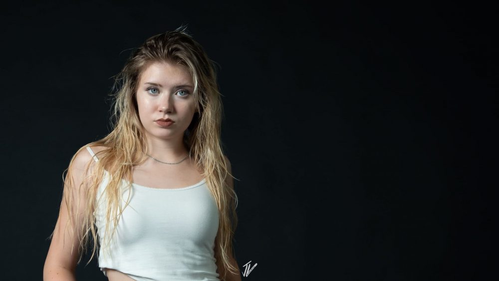 Studio Fashion Portrait von Naemi Krösche mit weißem Top und schwarzem Hintergrund