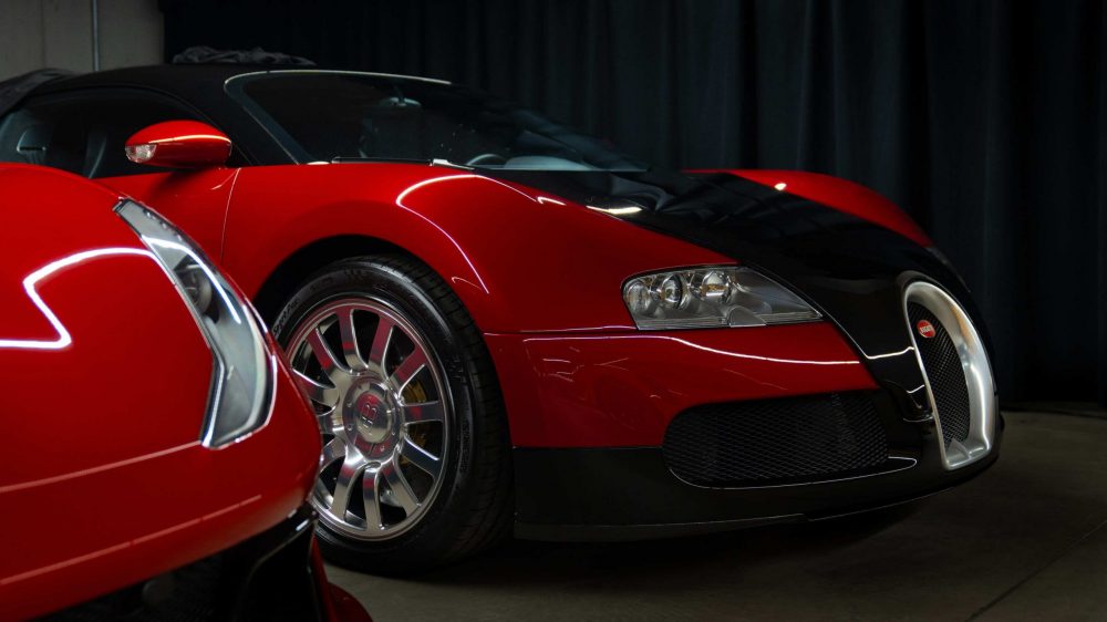 RR Motors Candy Shop Autohaus 25 Roter Bugatti Veyron in einer großen Garage.