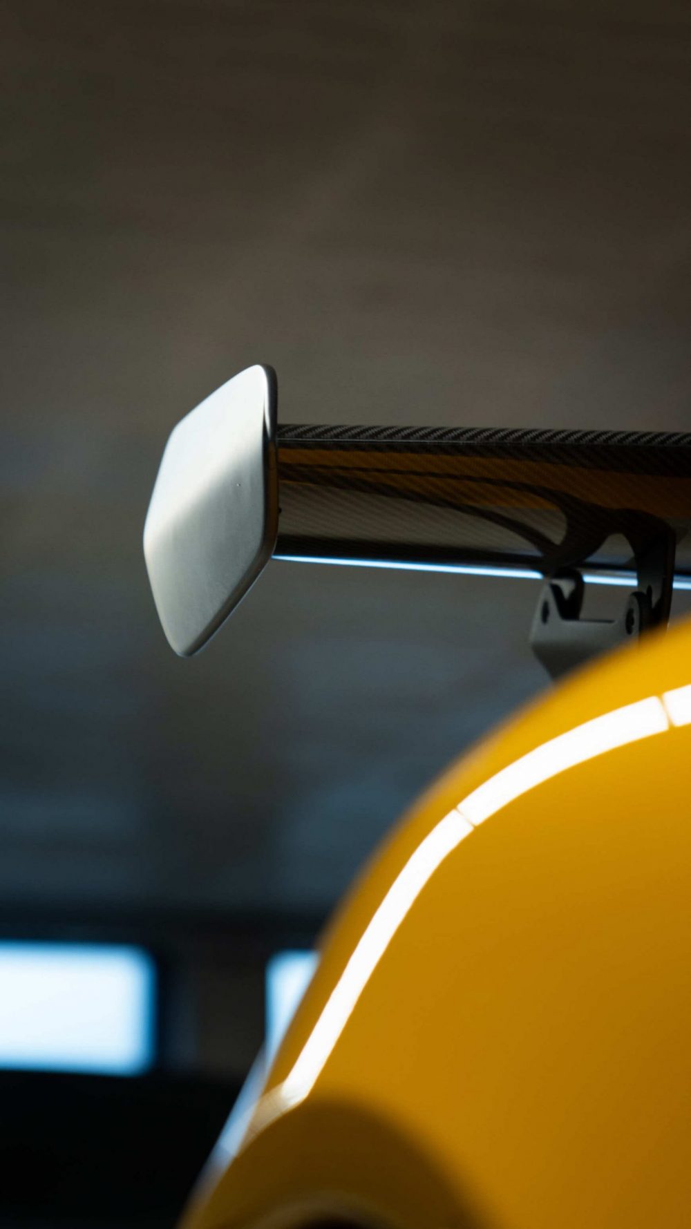 RR Motors Candy Shop Autohaus 17 Heckspoiler eines gelben Porsche im Autohaus RR-Motors.
