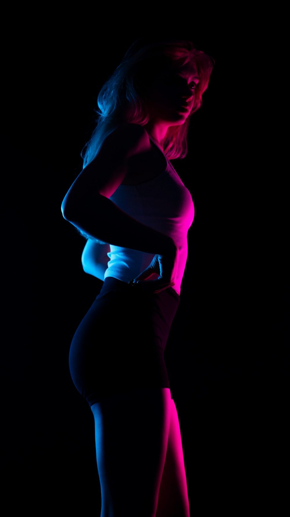 Naemi Krösche Model Shooting | HTL Paul Hahn, Linz Naemi Krösche als Silhouette im Profil in blauem und pinkem Licht im dunklen Studio
