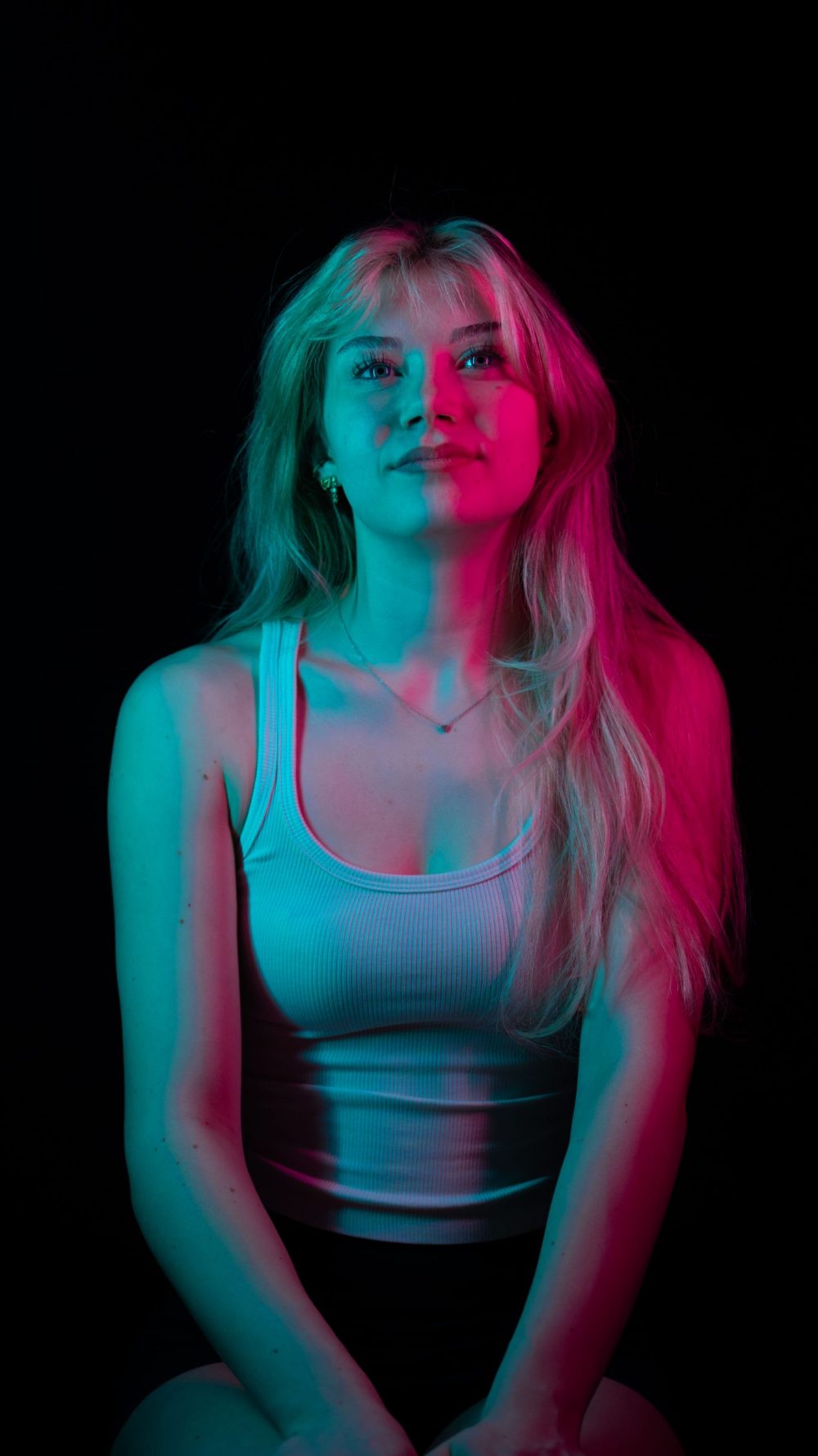 Naemi Krösche Model Shooting | HTL Paul Hahn, Linz Porträt von Naemi Krösche im weißen Top mit blauem und pinkem Licht im Gesicht