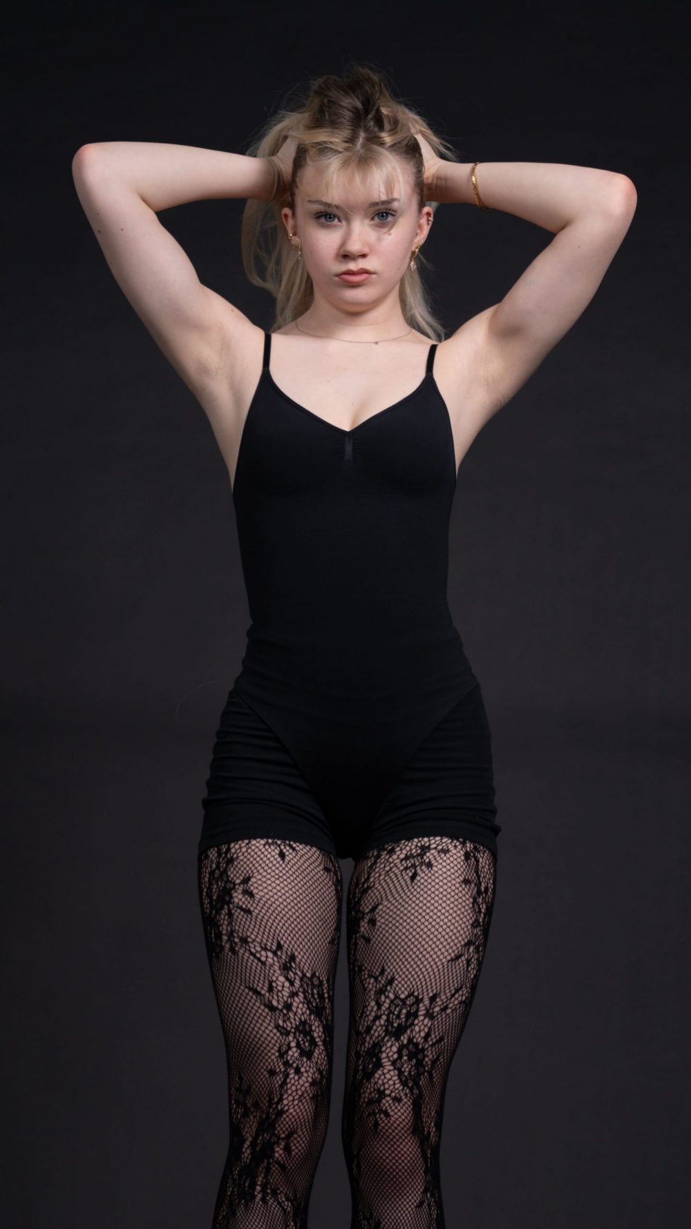 Naemi Krösche Model Shooting | HTL Paul Hahn, Linz Naemi Krösche im schwarzen Bodysuit mit beiden Händen hinter dem Kopf