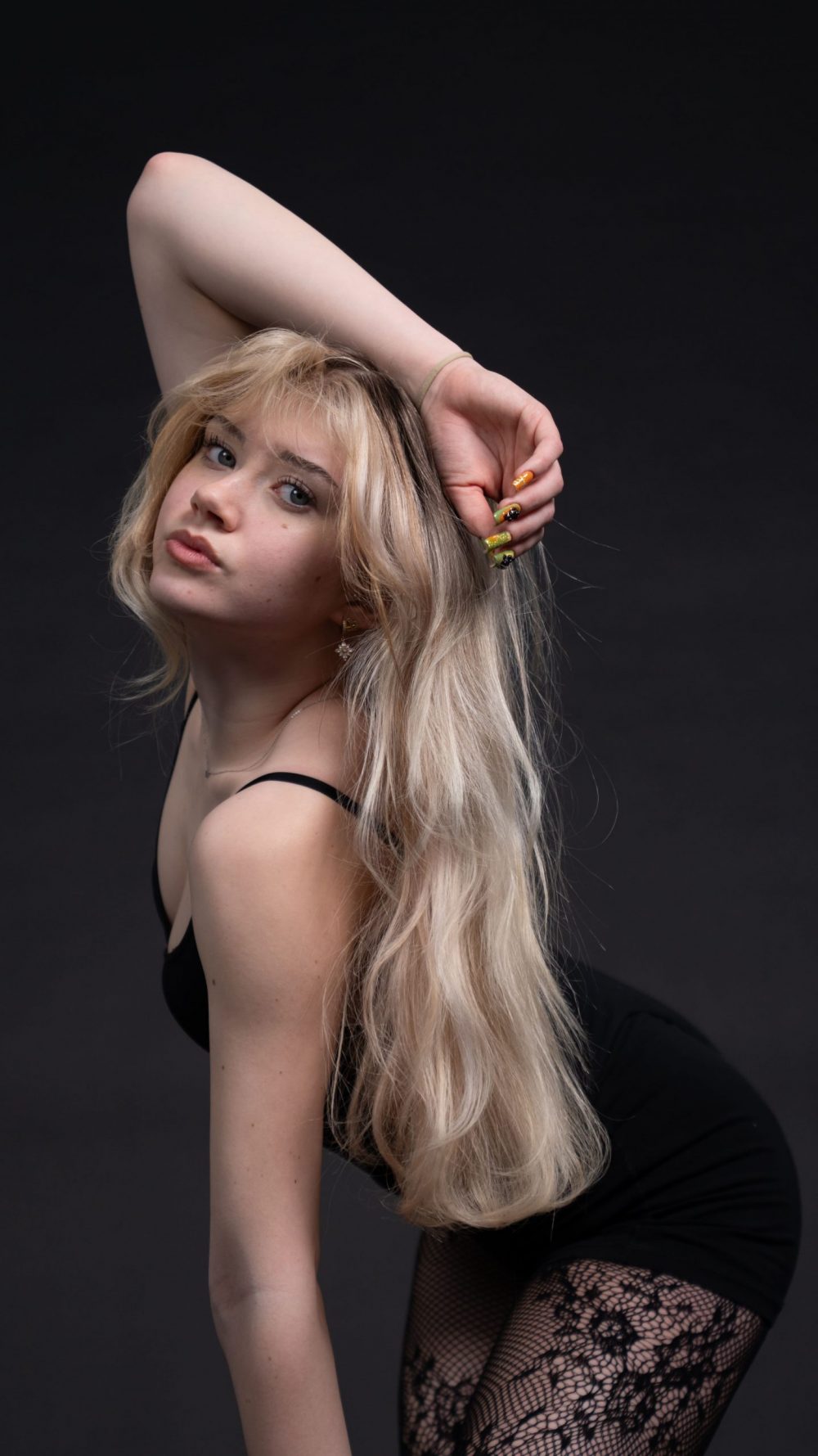 Naemi Krösche Model Shooting | HTL Paul Hahn, Linz Naemi Krösche beugt sich im schwarzen Bodysuit nach vorne, einen Arm über dem Kopf