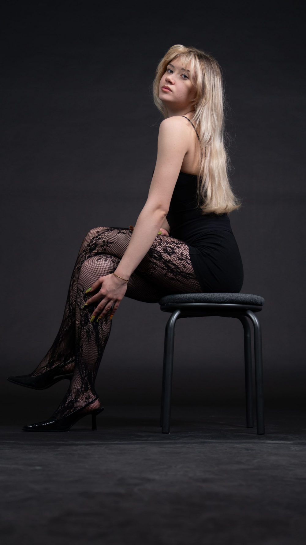 Naemi Krösche Model Shooting | HTL Paul Hahn, Linz Naemi Krösche sitzt seitlich auf einem Hocker im schwarzen Bodysuit