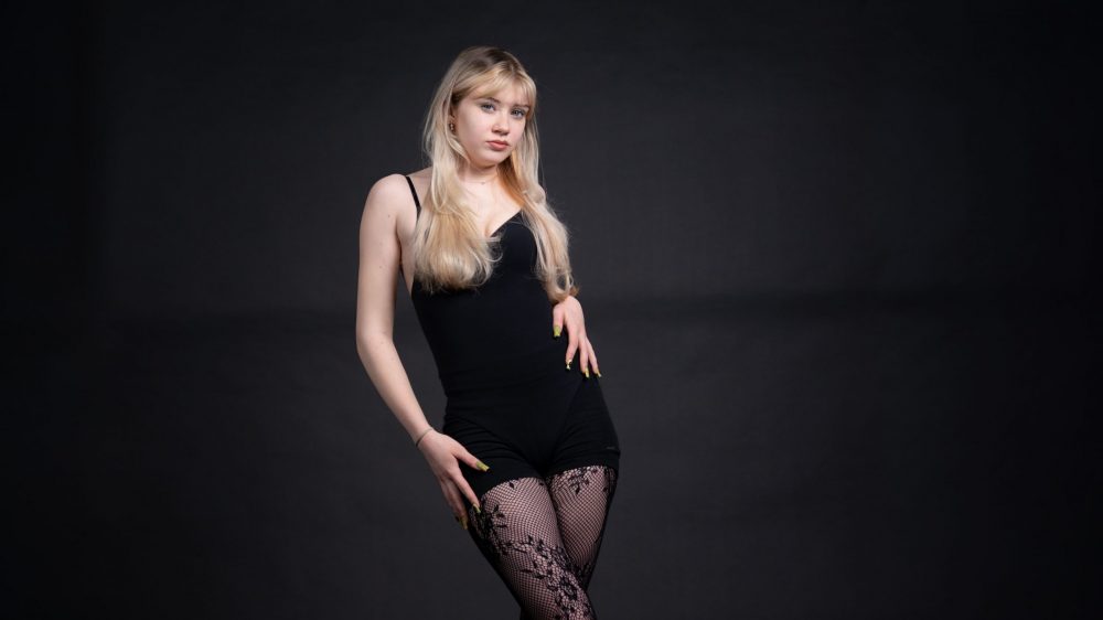 Naemi Krösche Model Shooting | HTL Paul Hahn, Linz Naemi Krösche steht im schwarzen Bodysuit in einem weiten Bildausschnitt im Studio