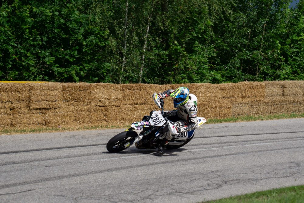 Bergrennen Julbach 2026 | Julbach, Oberösterreich Fahrer auf weißer Supermoto mit Knie am Boden entlang der Strohballen beim Julbach Bergrennen