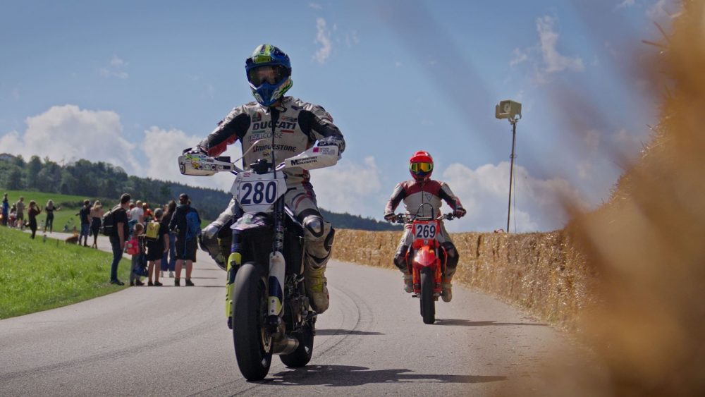 Bergrennen Julbach 2026 | Julbach, Oberösterreich Supermoto Fahrer im Stehen bei der Rückführung, im Vordergrund ein Strohballen, Julbach Bergrennen