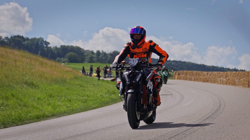 Bergrennen Julbach 2026 | Julbach, Oberösterreich Motorradfahrer in Lederkombi in Orange und Schwarz bei der Rückführung unter blauem Himmel in Julbach