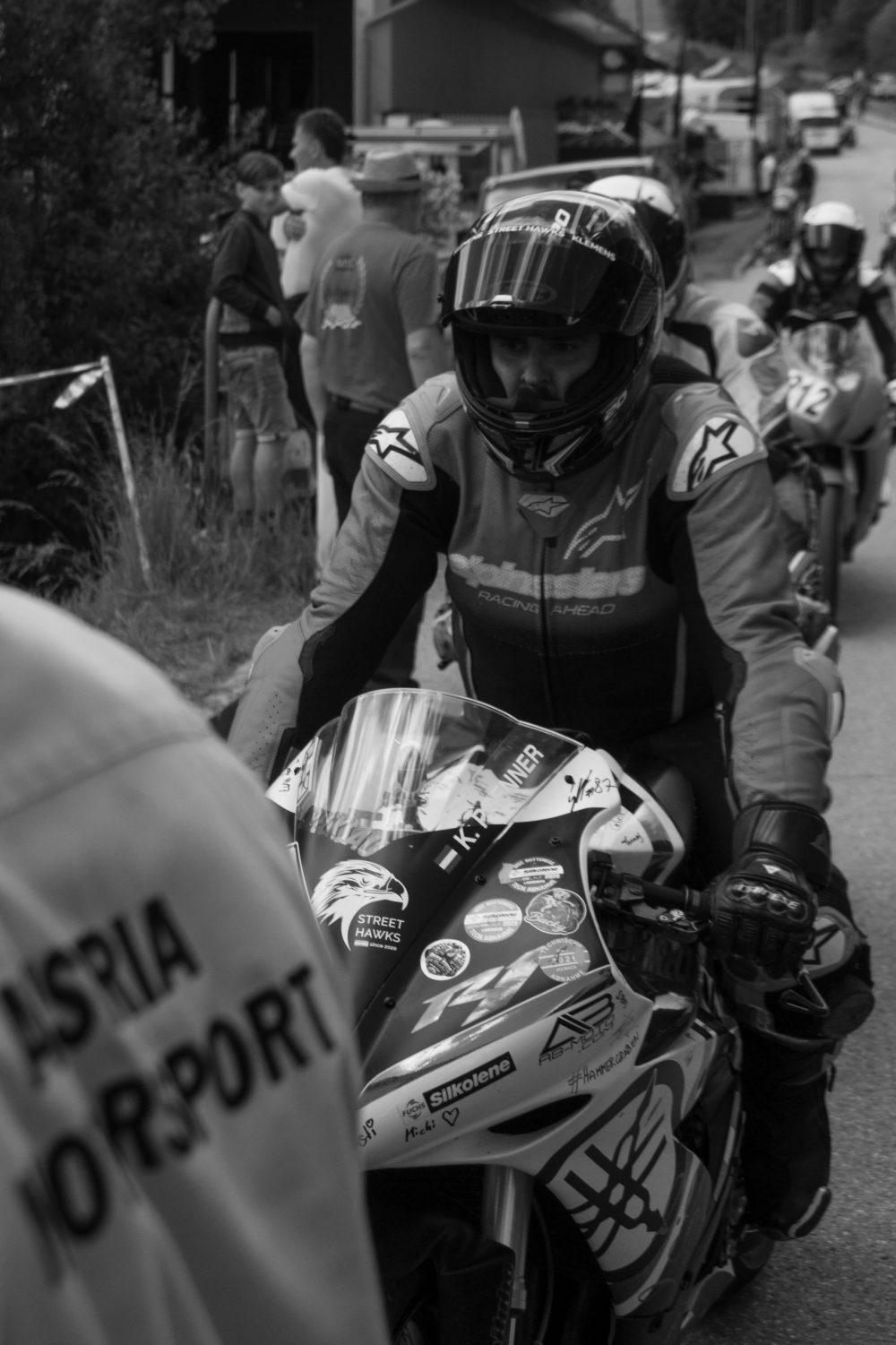 Bergrennen Julbach 2026 | Julbach, Oberösterreich Rennfahrer lehnt am Start an seinem Motorrad, Schwarzweißfoto vom Bergrennen Julbach 2026
