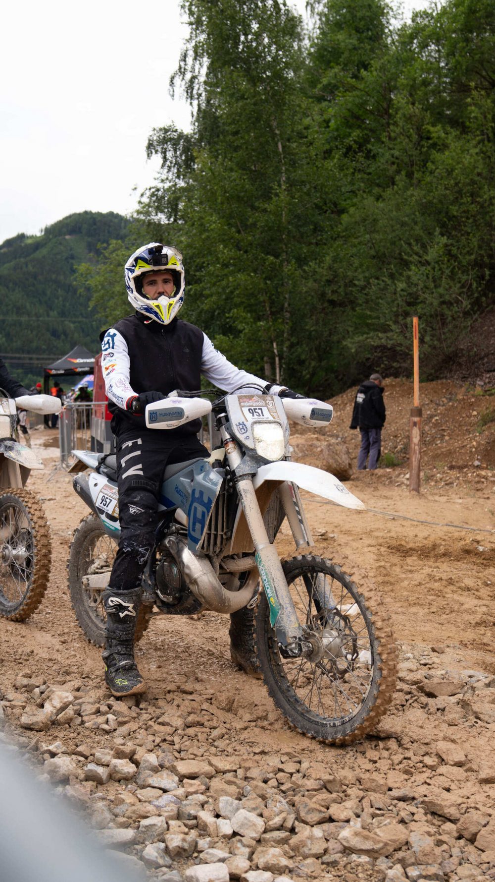 Fahrer auf einer weißen Husqvarna auf dem Schotterweg am Erzberg