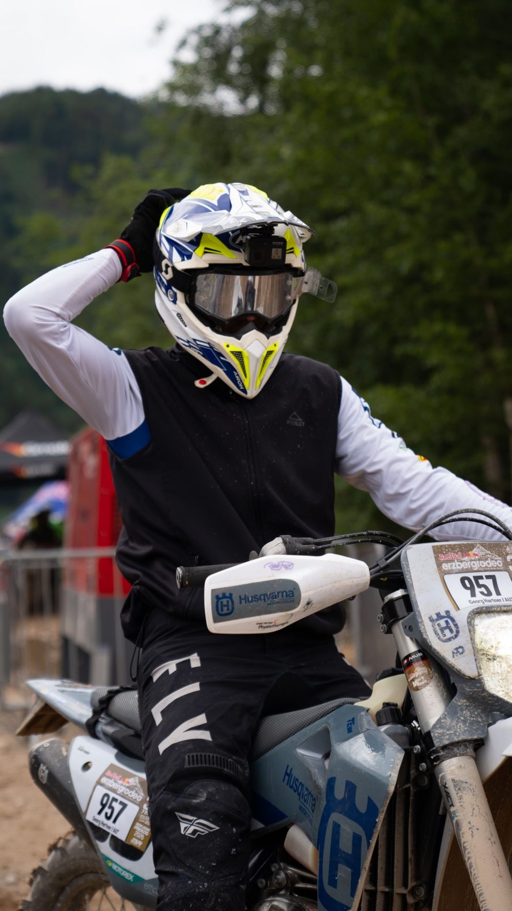Fahrer auf einer Husqvarna rückt vor dem Start seinen Helm zurecht