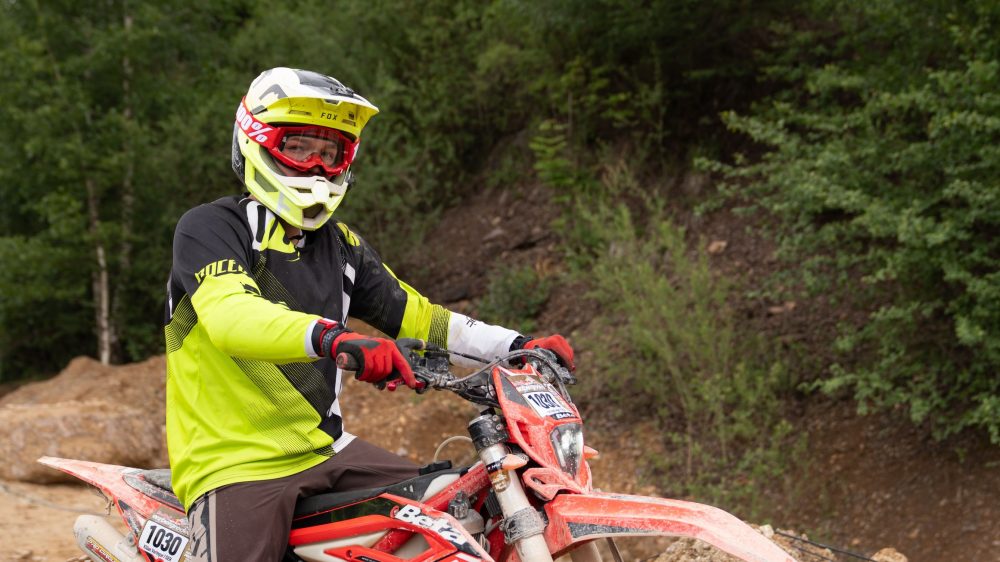 Endurofahrer in neongelber Jacke zwischen den Bäumen im Wald am Erzberg