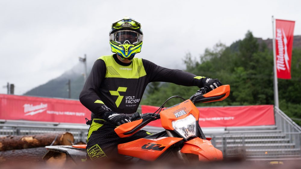 Jakub Zręda im VOLTFACTORY® Trikot auf der FREERIDE E neben einer Red Bull Fahne