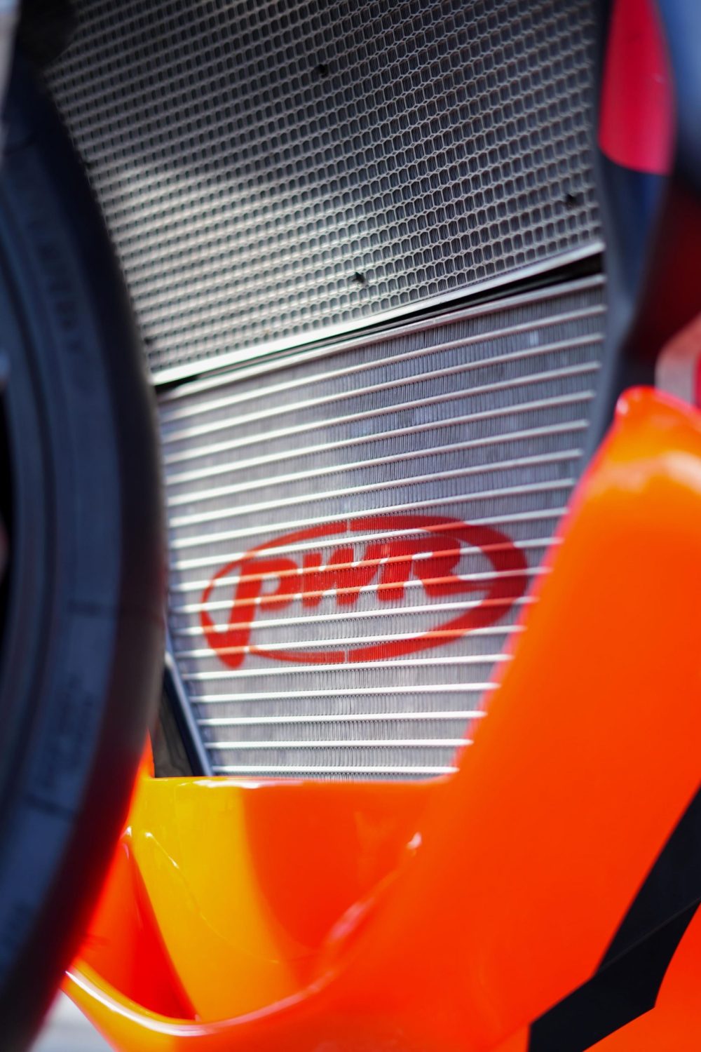 Kühler und oranger Rahmen eines Rennmotorrads in Nahaufnahme beim AB Moto Sommerfest