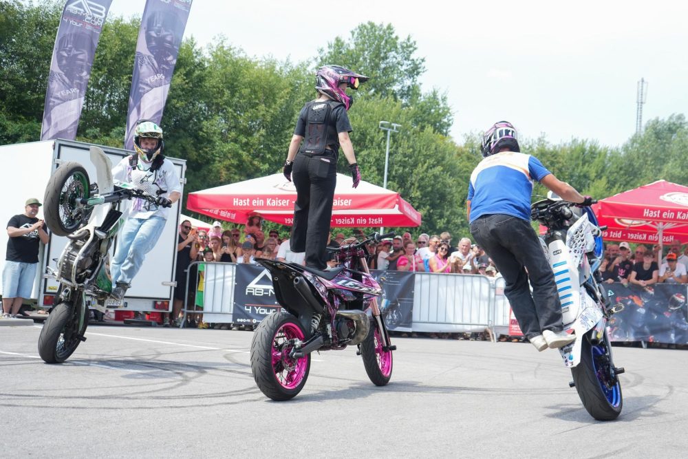 Zwei Stuntfahrer stehen auf ihren Motorrädern vor dem Publikum beim AB Moto Sommerfest 2026
