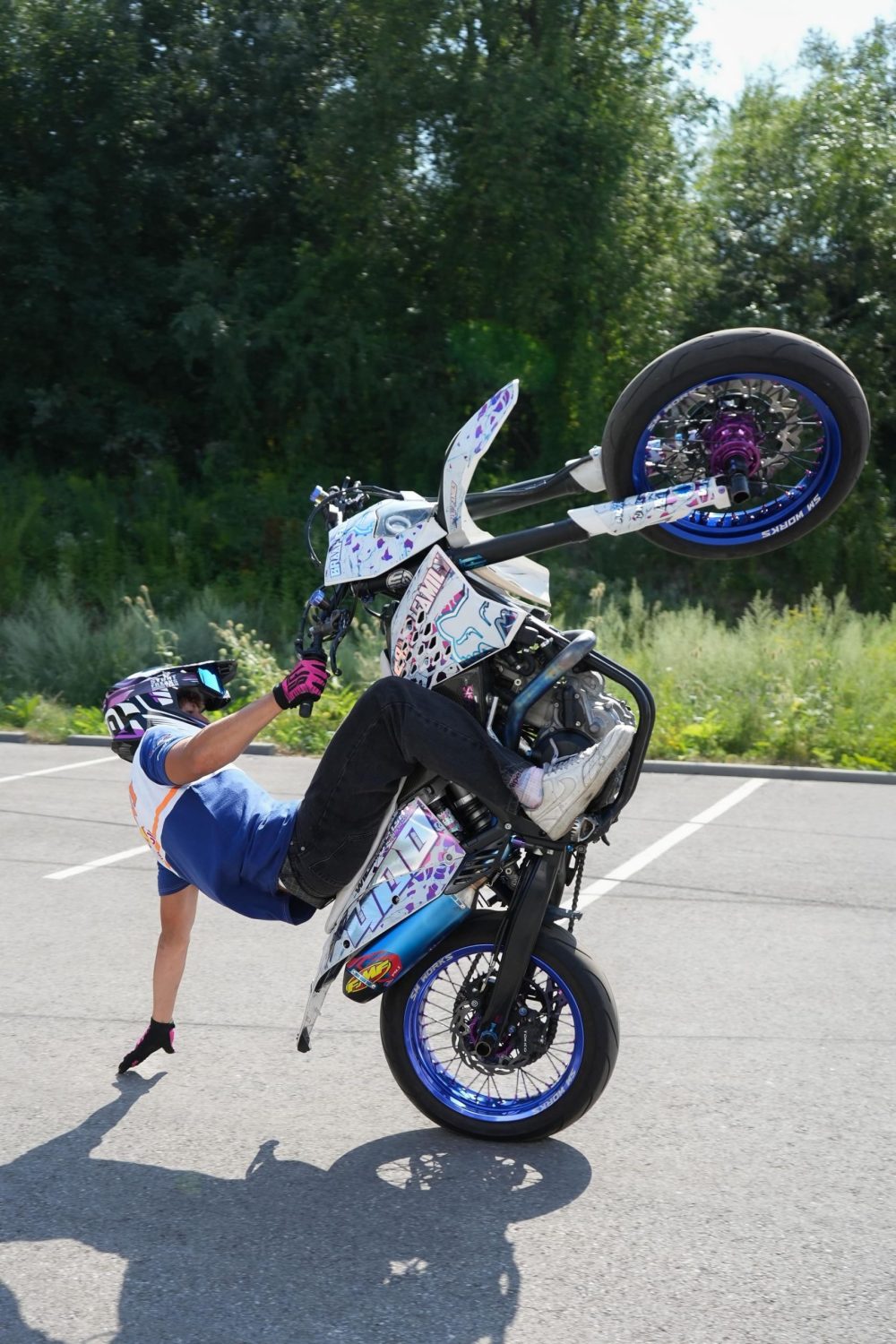 Stuntfahrer schleift beim Wheelie mit der Hand über den Asphalt, AB Moto Sommerfest 2026