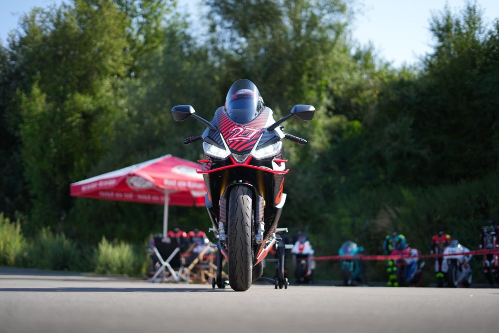 Aprilia RS660 frontal zwischen den Zelten beim Sommerfest von AB-Moto