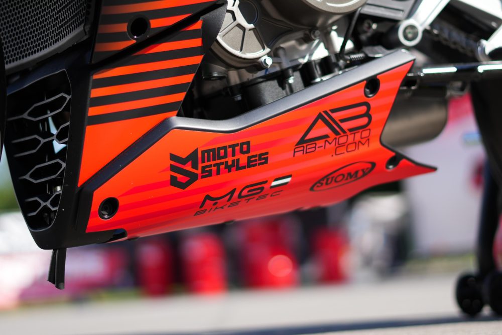 Motostyles Dekor mit AB-Moto Logo an einer orangen Verkleidung
