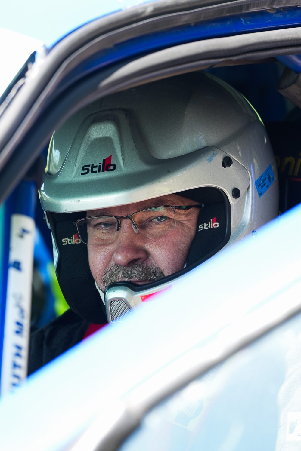 Bergrennen St. Agatha 2026 | Oberösterreich Fahrer mit weißem Stilo Helm und Brille blickt aus dem Cockpit in die Kamera