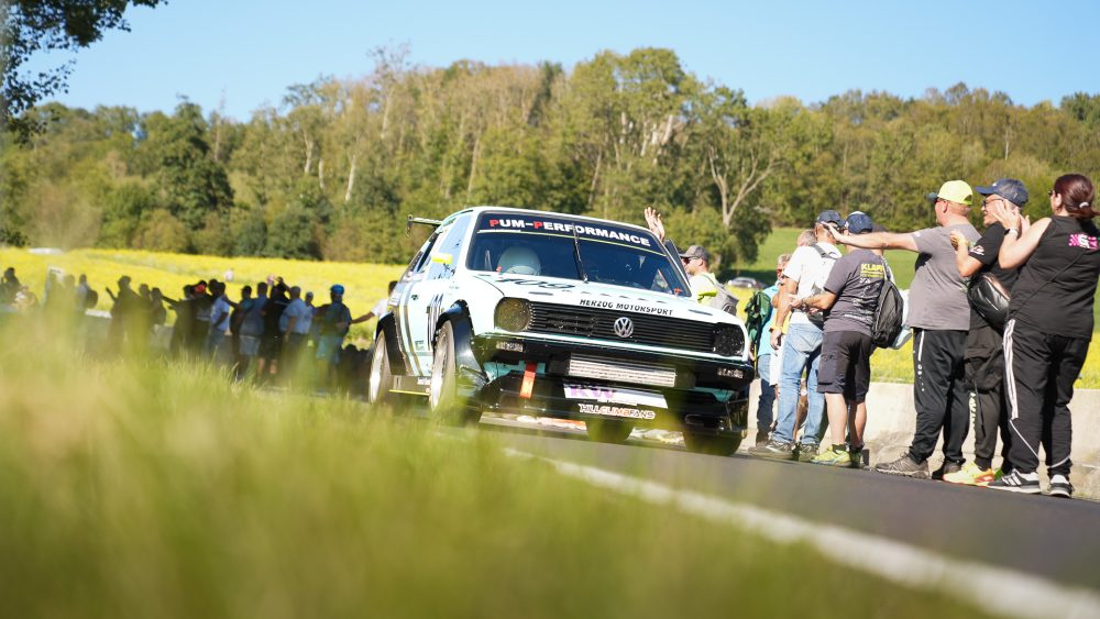 Bergrennen St. Agatha 2026 | Oberösterreich Weißer VW Golf 1 steht startbereit auf der Wiese, umringt von zahlreichen Zuschauern
