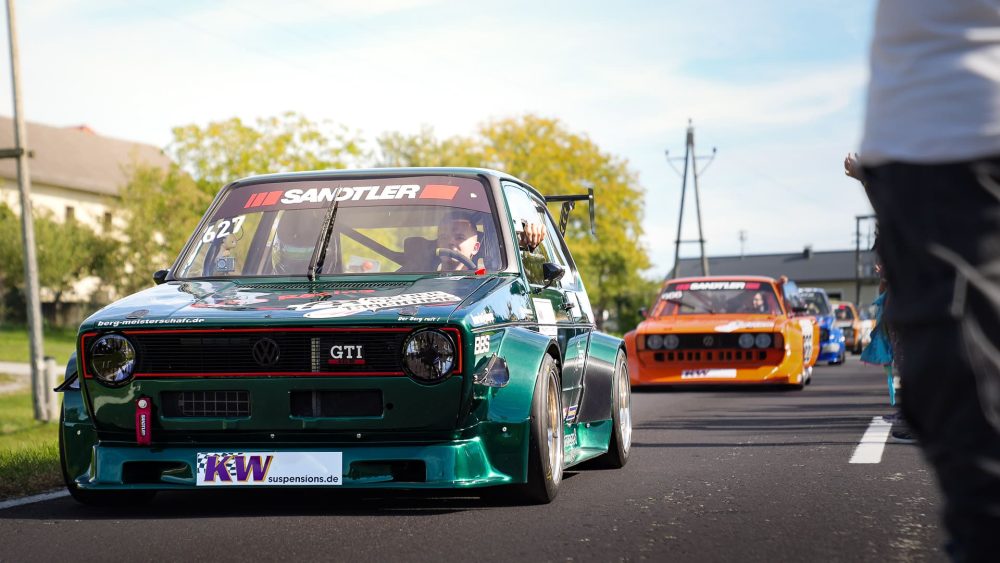 VW Golf GTI in der Startaufstellung Dunkelgrüner VW Golf GTI Rennwagen in der Startaufstellung, dahinter ein oranger Rennwagen