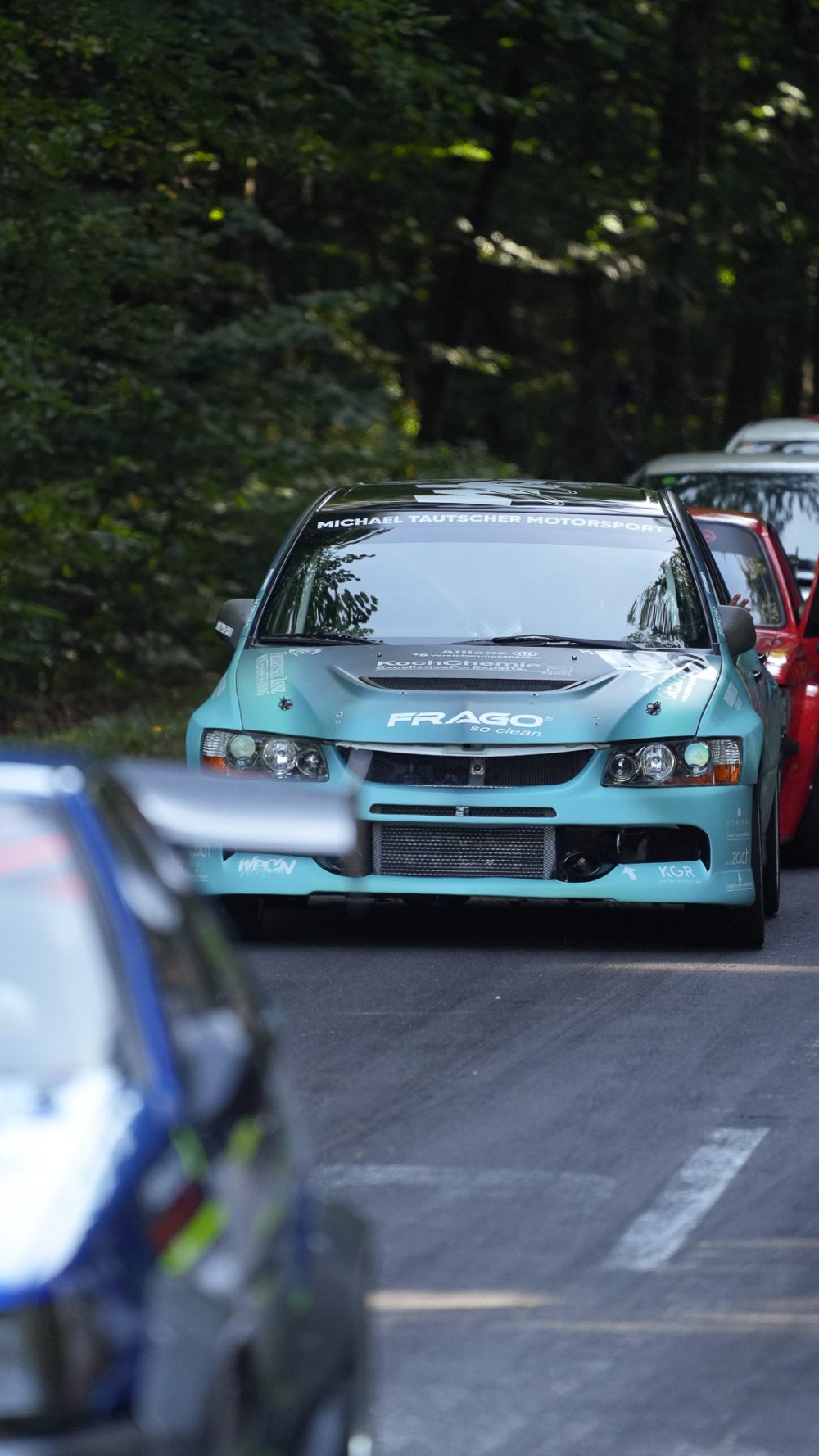 Wartende Fahrzeuge Türkisfarbener Mitsubishi Lancer Evolution in einer Fahrzeugkolonne auf der Straße