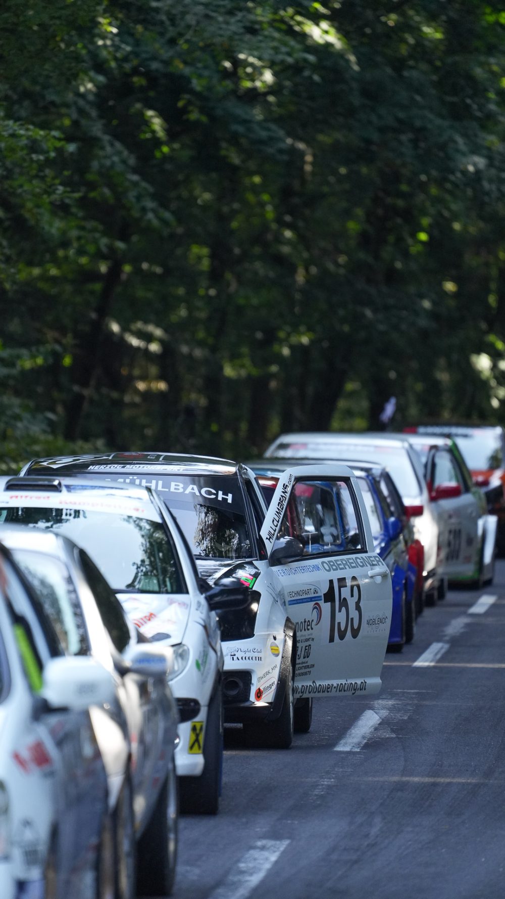 Warten auf den Start Kolonne weißer Rennwagen, einer mit Startnummer 153, wartet auf der Straße